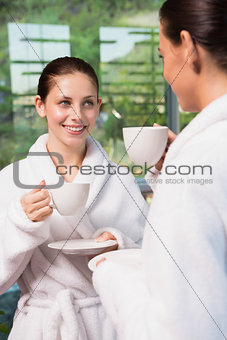 Women in bathrobes having tea