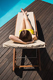 Beautiful woman in bikini relaxing by pool