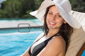 Beautiful woman relaxing by swimming pool