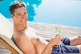 Man holding champagne flute by the swimming pool