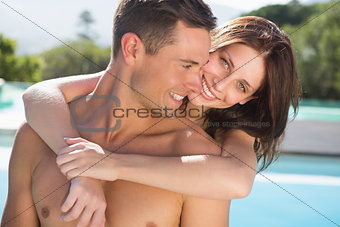 Romantic woman embracing man by swimming pool