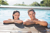 Smiling couple in swimming pool on a sunny day