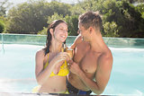 Couple with champagne flutes by swimming pool