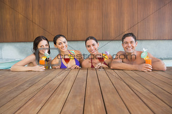 Cheerful people with drinks in swimming pool