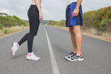 Side view low section of fit couple standing on road