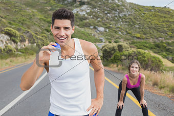 Portrait of a fit couple standing on road