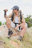 Hiking man sitting on mountain terrain