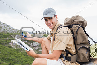Hiking man with map on mountain terrain