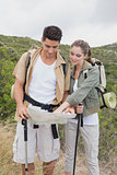 Couple looking at map on mountain terrain