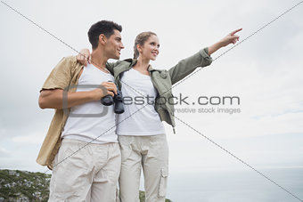 Hiking couple with binoculars on mountain terrain
