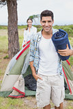 Happy couple with tent on countryside landscape