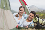 Happy couple in tent on countryside landscape