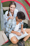 Couple using laptop in tent