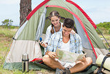 Couple looking at map outside their tent
