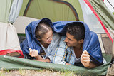 Happy young couple lying in tent