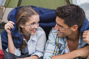 Happy young couple lying in tent