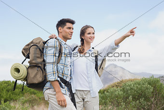 Couple pointing and smiling on country terrain