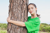 Female environmental activist hugging tree trunk