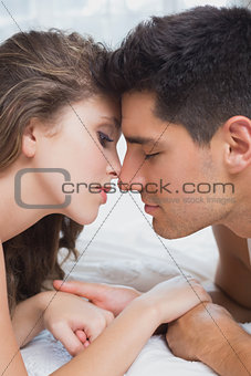 Side view of romantic couple in bed at home