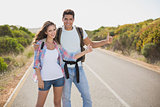 Couple hitchhiking on countryside road