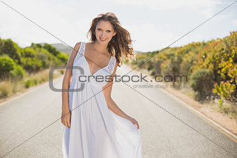 Smiling woman standing on countryside road
