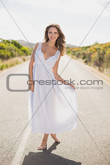Smiling woman standing on countryside road