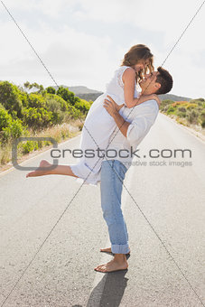 Man carrying woman on countryside road