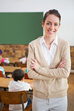 Pretty teacher smiling at camera at back of classroom