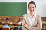 Pretty teacher smiling at camera at back of classroom