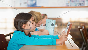 Pupils sitting in classroom reading books