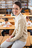 Pretty teacher smiling at camera at top of classroom