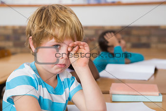 Upset pupil sitting at his desk
