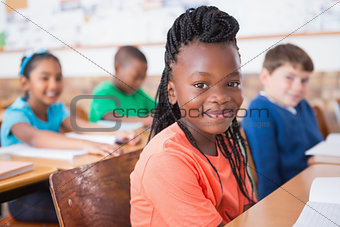 Cute pupils listening attentively in classroom