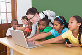 Teacher and pupils looking at laptop