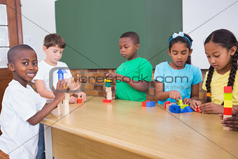 Cute pupils playing with building blocks