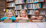 Cute pupils smiling at camera in library