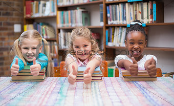 Cute pupils smiling at camera in library