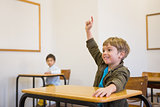 Pupil raising his hand at his desk