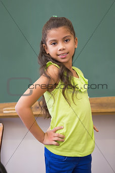 Cute pupil standing in classroom