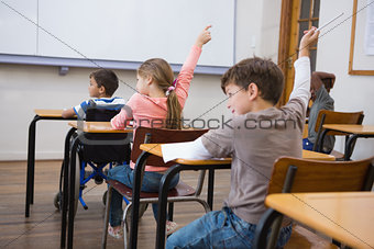 Pupils raising their hands during class