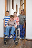 Disabled pupil with his friends in classroom