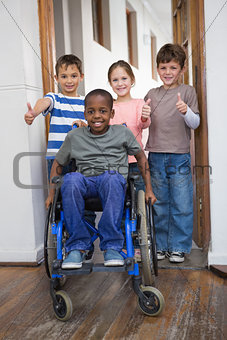 Disabled pupil with his friends in classroom