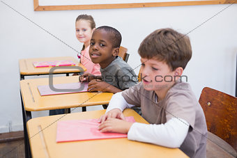 Cute pupils listening attentively in classroom