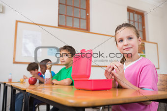 Cute pupils having their lunch in classroom