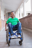 Cute disabled pupil smiling at camera in hall