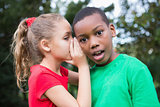 Cute children sharing gossip outside