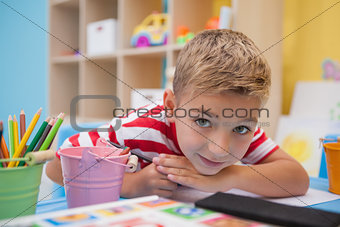 Cute little boy drawing at desk