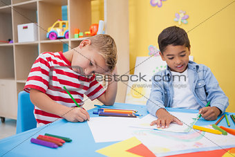 Cute little boys drawing at desk