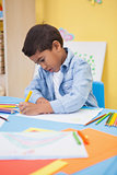 Cute little boy drawing at desk