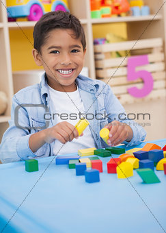 Cute little boy playing with building blocks